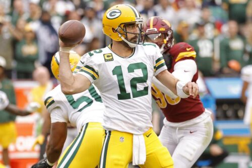 
Oct 23, 2022; Landover, Maryland, USA; Green Bay Packers quarterback Aaron Rodgers (12) passes the ball as Washington Commanders defensive end Montez Sweat (90) chases during the fourth quarter at FedExField. Mandatory Credit: Geoff Burke-USA TODAY Sports
