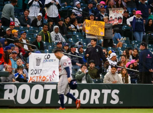 
May 27, 2022; Seattle, Washington, USA; Seattle Mariners fans hold up signs referencing the Houston Astros sign-stealing controversy as Houston Astros second baseman Jose Altuve (27) walks off the field after the seventh inning at T-Mobile Park. Mandatory Credit: Lindsey Wasson-USA TODAY Sports
